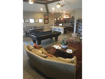 A living room with a pool table and a couch.